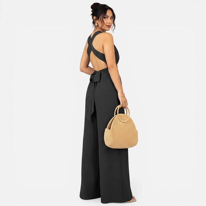 Laurior | Combinaison habillée dos nu pour femme, coupe large, vue arrière avec un sac en osier.