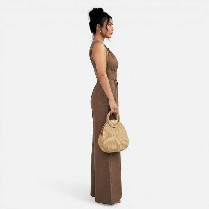 Laurior | Combinaison habillée dos nu pour femme, coupe large vue de profil avec un sac en osier.