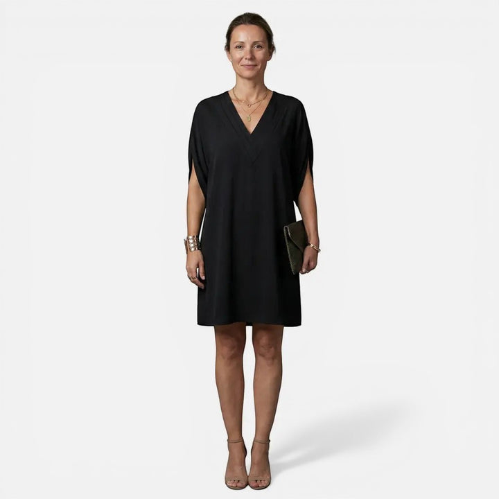 Laurior | Robe midi plissée élégante à col en V pour femme portée par une femme, couleur noire.