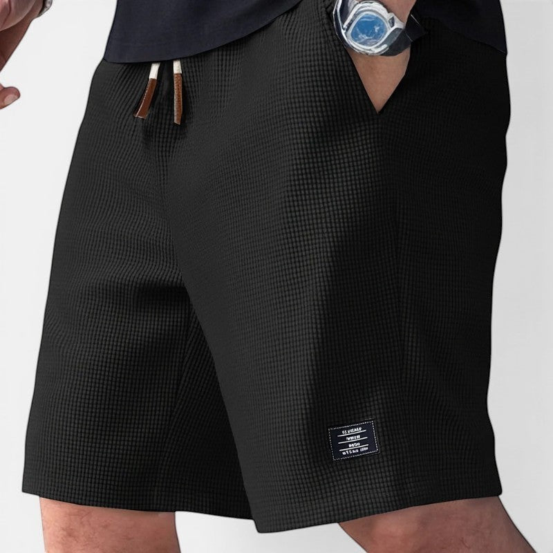 Laurior | Short en Maille Homme Doux Structuré Style Décontracté en noir avec détail de poches et étiquette.