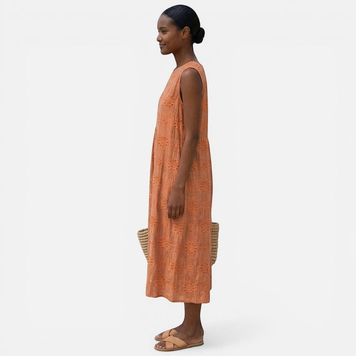 Laurior | Robe sans manches intemporelle taille plissée confort vue de profil, modèle portant une robe élégante orange.