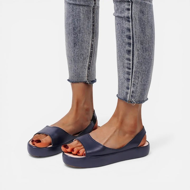 Laurior | Sandales ouvertes en cuir pour femmes avec bride arrière, portant avec un jean ajusté.