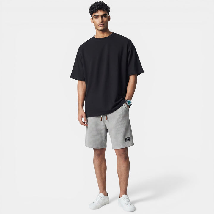 Laurior | Short en Maille Homme Doux Structuré Style Décontracté porté par un homme jeune en t-shirt noir.