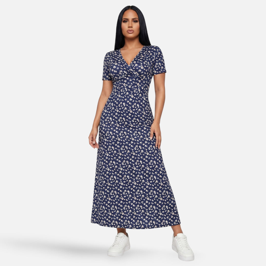 Laurior | Robe longue portefeuille fleurie silhouette empire pour femme, élégante et féminine, en fleurs sur fond bleu.
