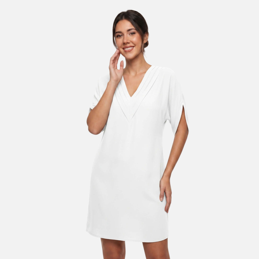 Laurior | Robe mini fluide col V plissé épuré pour femme portée par modèle dans un style minimaliste chic.